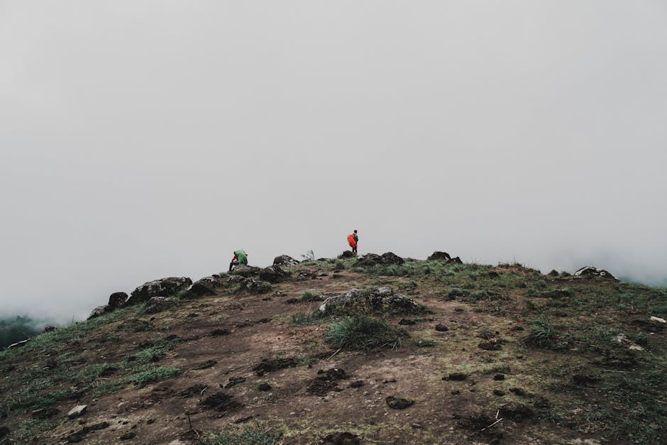 Two hikers on a misty mountain peak, showcasing adventure and exploration